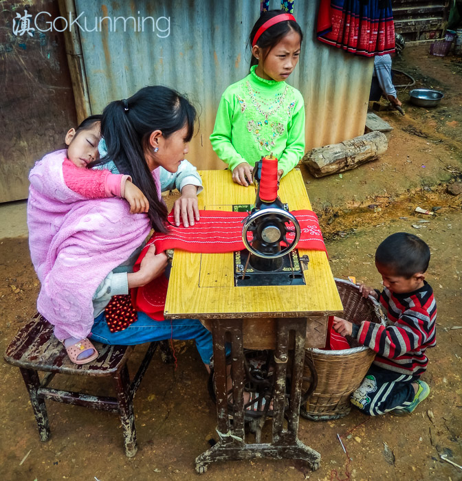 Miao woman making clothes outside her home