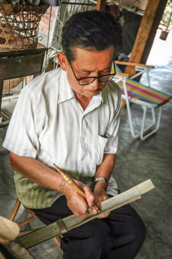 Inscribing a palm leaf manuscript