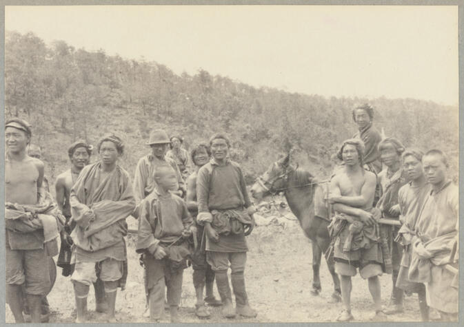 Group of people in native dress with two mounted on horses June 2, 1922