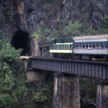 An old passenger train heads toward a tunnel on the Kunming Haiphong Railway