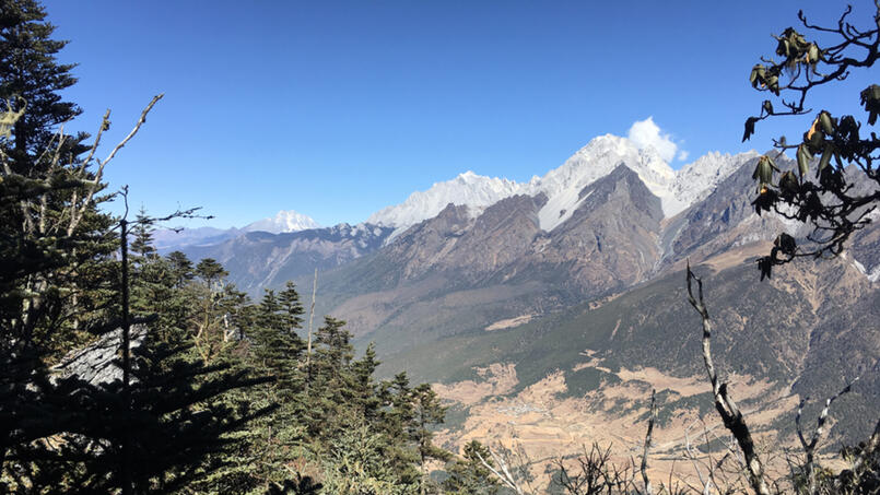 Haba Snow Mountain (left) and Jade Dragon Snow Mountain (right). Snowflake Village in valley below. Photo taken from summit ridge of Wenhai Mountain