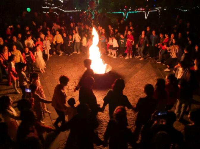 Zhuang people are dancing and singing aroung the "welcoming fire"